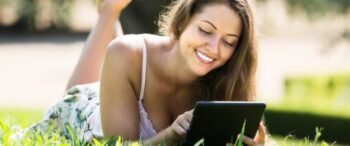 girl-lying-on-grass-with-ereader_1398-4660